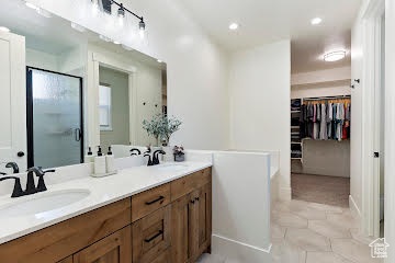 Bathroom featuring vanity, tile patterned floors, and a shower with door