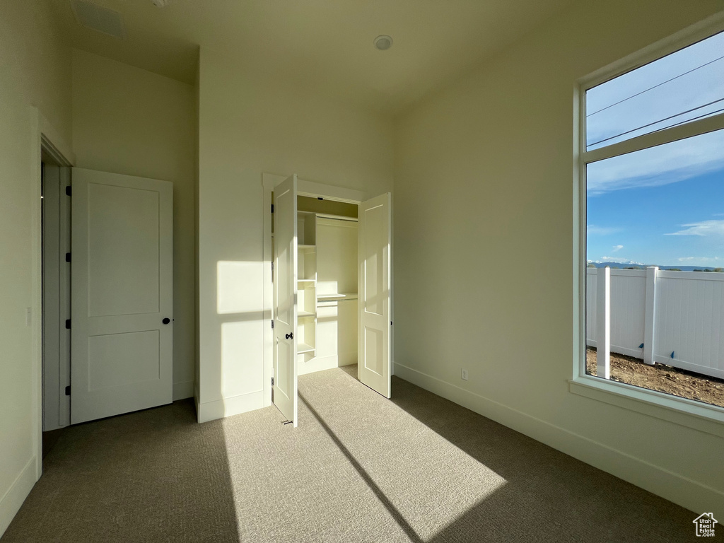 Unfurnished bedroom with carpet floors, baseboards, and a closet