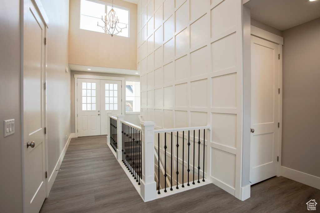 Stairs featuring a notable chandelier and wood-type flooring