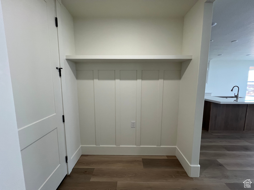 Mudroom with baseboards, a sink, and wood finished floors