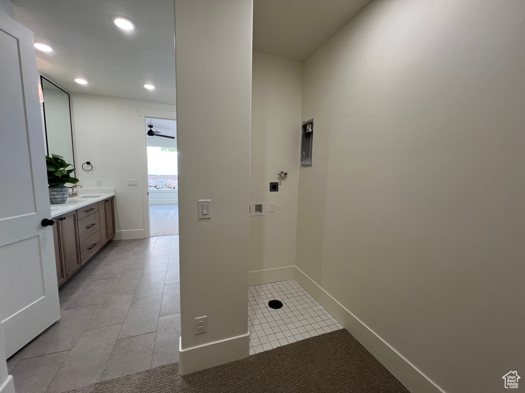 Laundry area with light tile patterned floors, baseboards, a sink, hookup for a washing machine, and recessed lighting