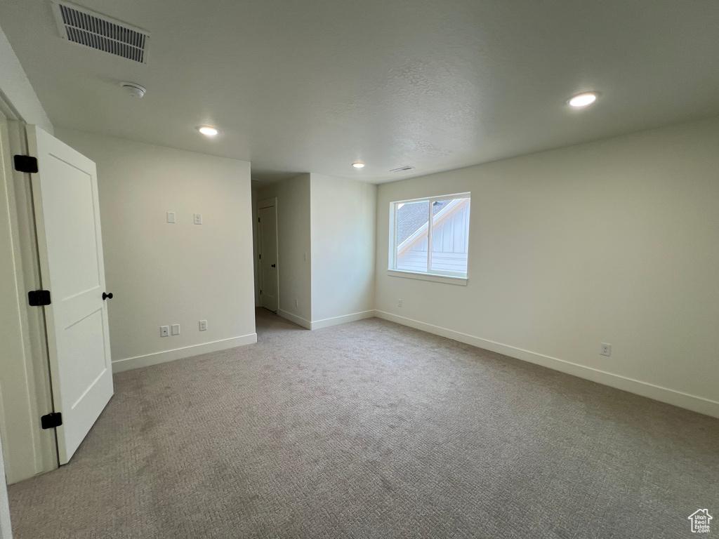 Empty room featuring carpet flooring, recessed lighting, baseboards, and visible vents