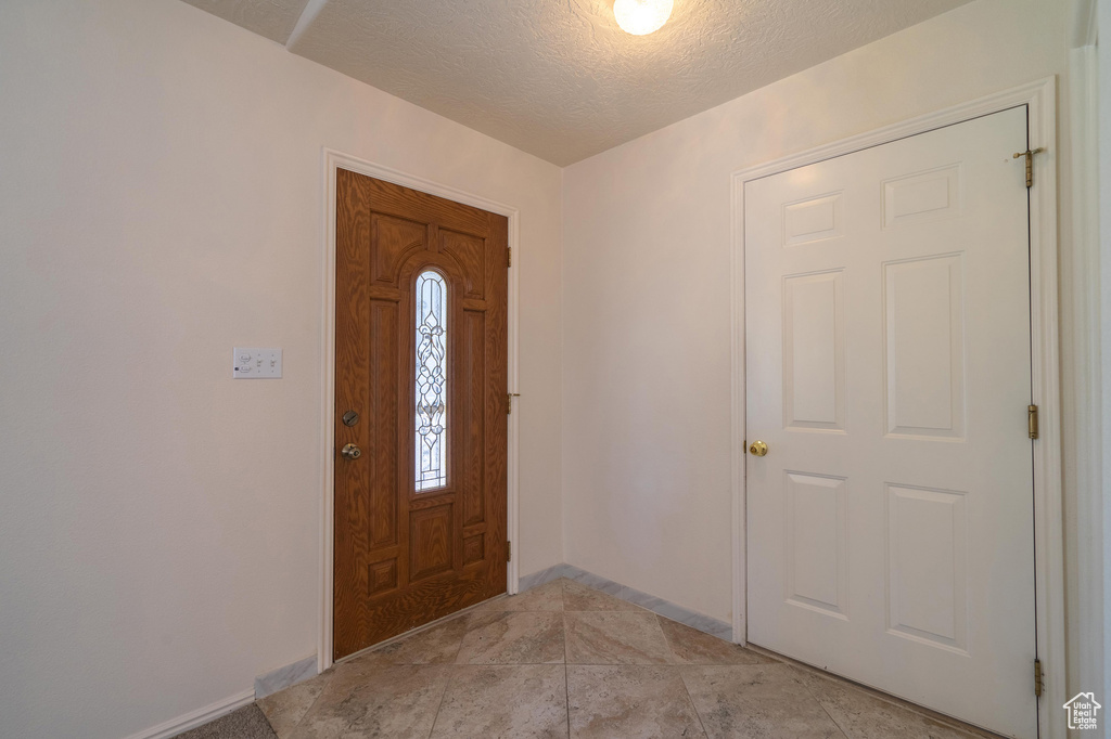 Tiled entrance foyer featuring a textured ceiling