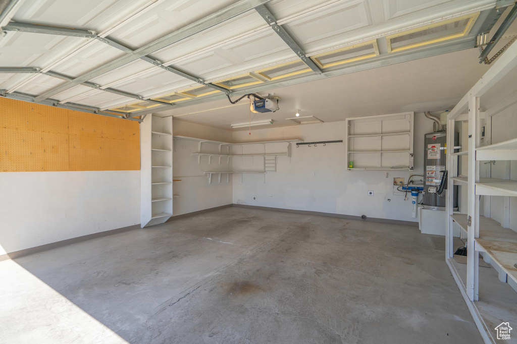 Garage featuring a garage door opener and water heater