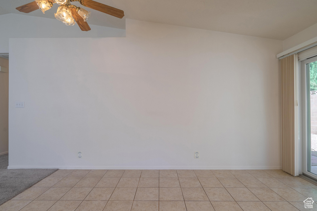 Tiled spare room with ceiling fan and vaulted ceiling