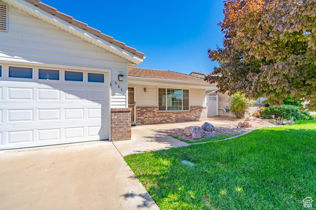 View of front of home with a garage and a front yard