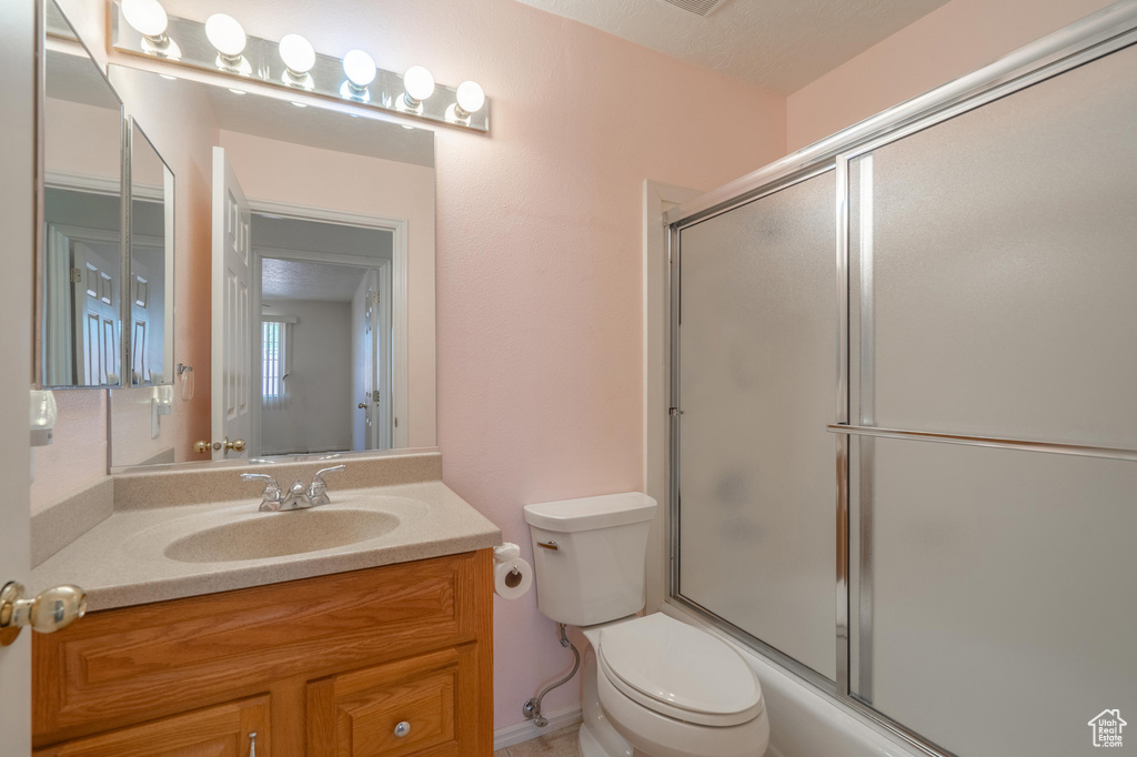 Full bathroom featuring vanity, toilet, and enclosed tub / shower combo