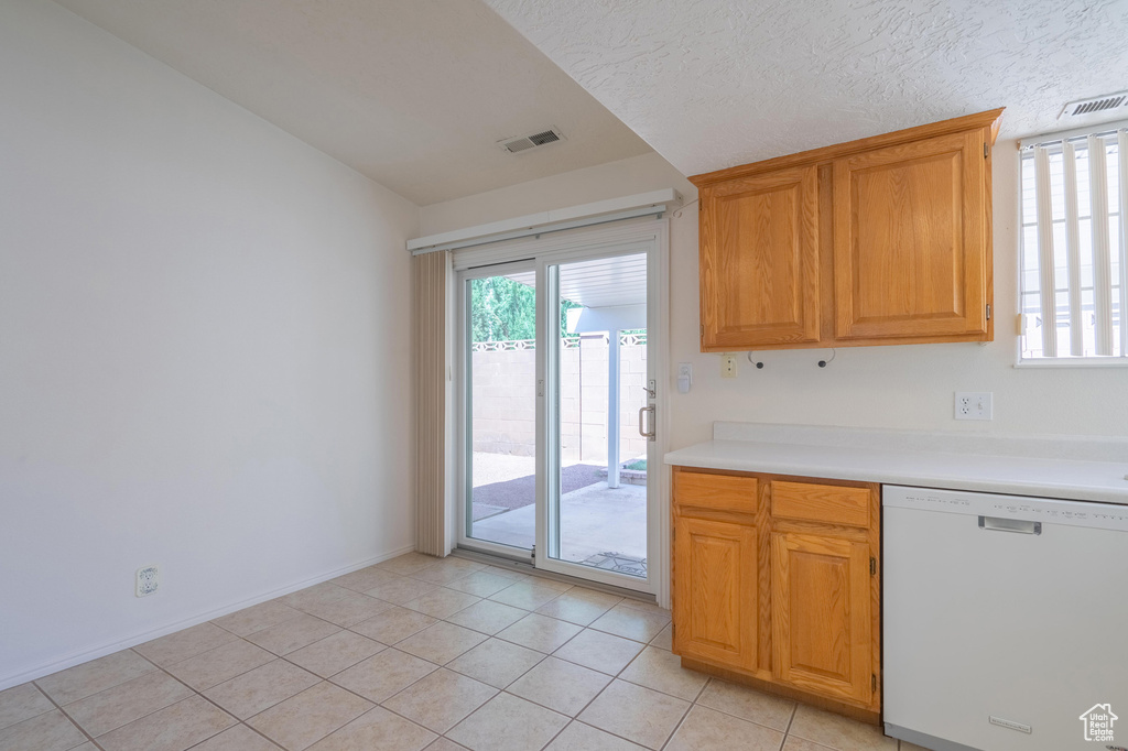 Kitchen with light tile patterned floors, a textured ceiling, and white dishwasher