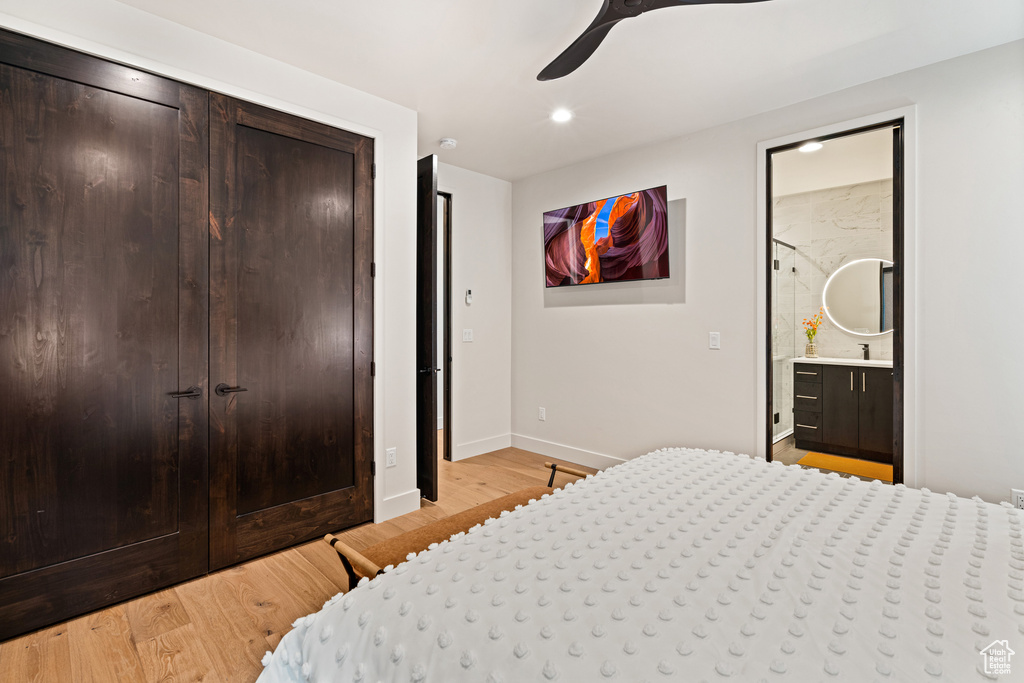 Bedroom featuring light hardwood / wood-style flooring, ceiling fan, a closet, and ensuite bathroom