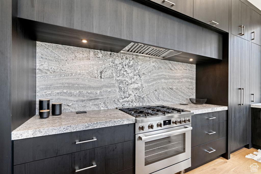 Kitchen featuring range hood, stainless steel range, and light hardwood / wood-style floors