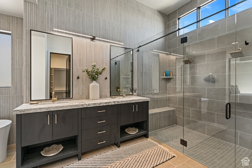 Bathroom featuring tile patterned flooring, vanity, and plus walk in shower