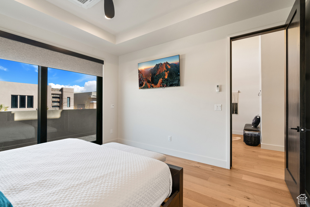 Bedroom with ceiling fan, light hardwood / wood-style floors, and access to exterior