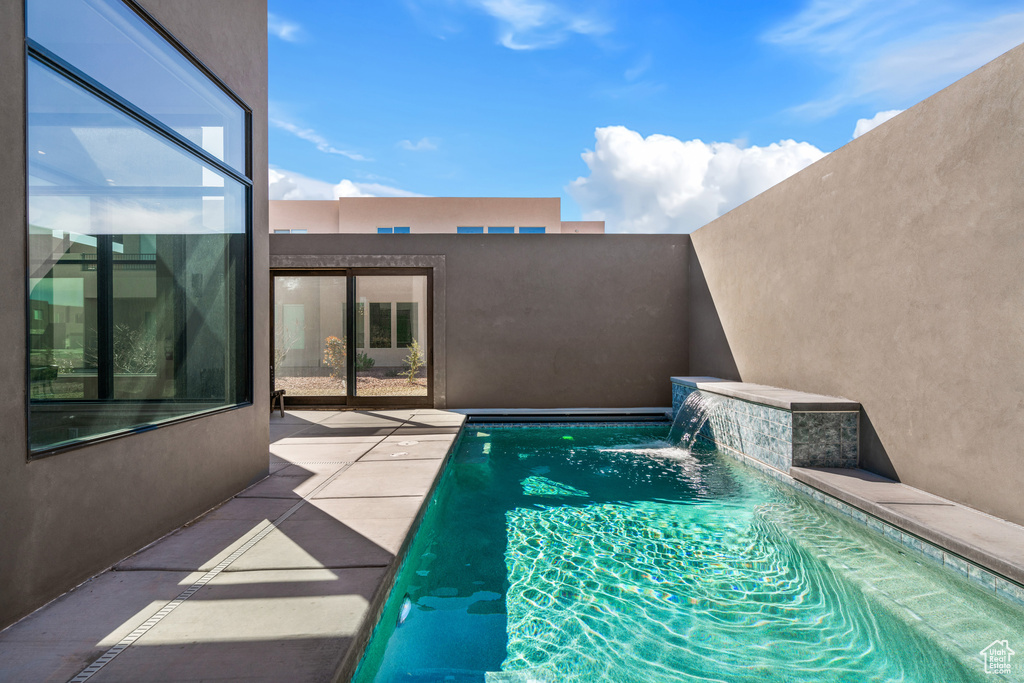 View of swimming pool with pool water feature and a patio area