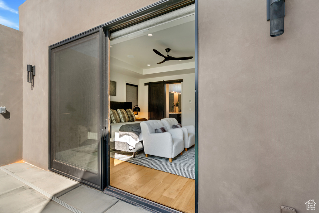 Interior space featuring a barn door, wood-type flooring, and ceiling fan