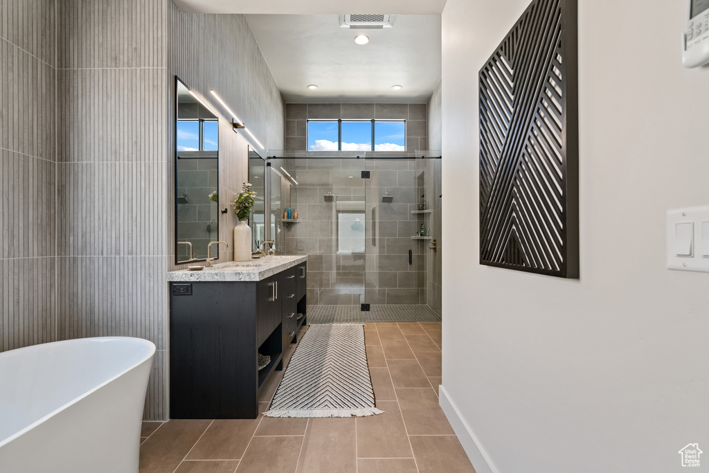 Bathroom with vanity, tile patterned floors, and plus walk in shower