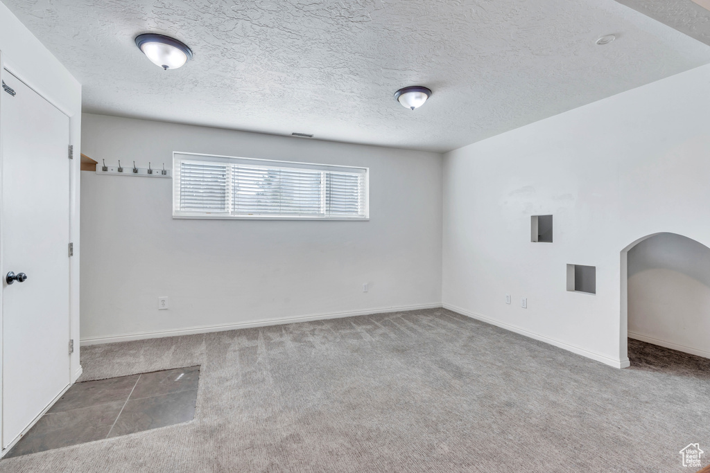 Carpeted empty room with a textured ceiling