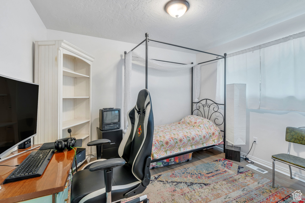 Bedroom featuring hardwood / wood-style flooring and a textured ceiling