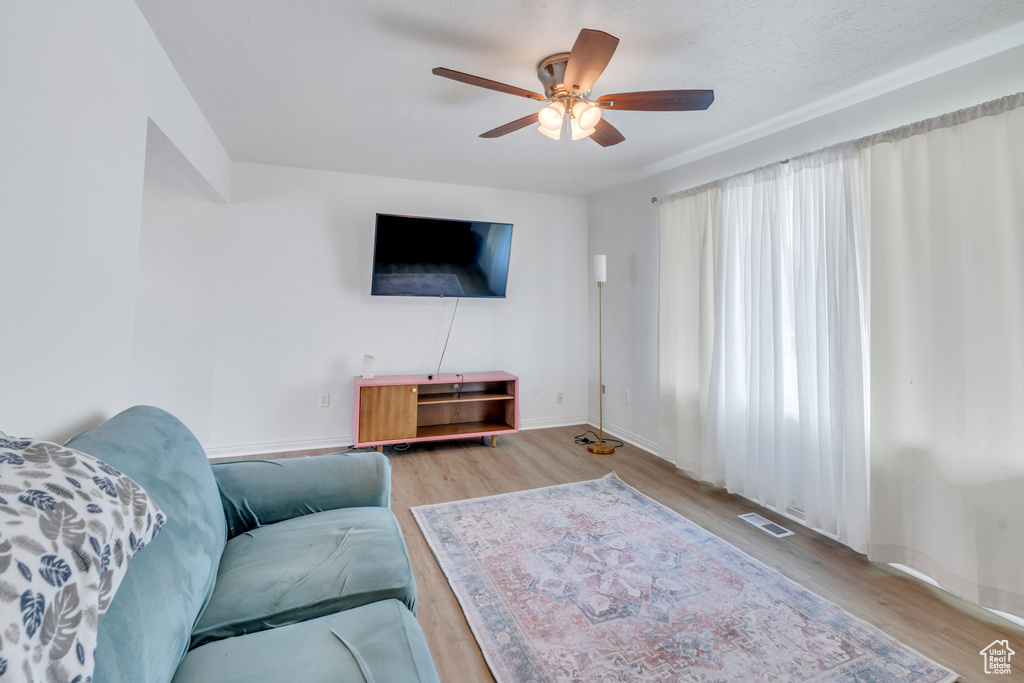 Living room featuring ceiling fan and light wood-type flooring