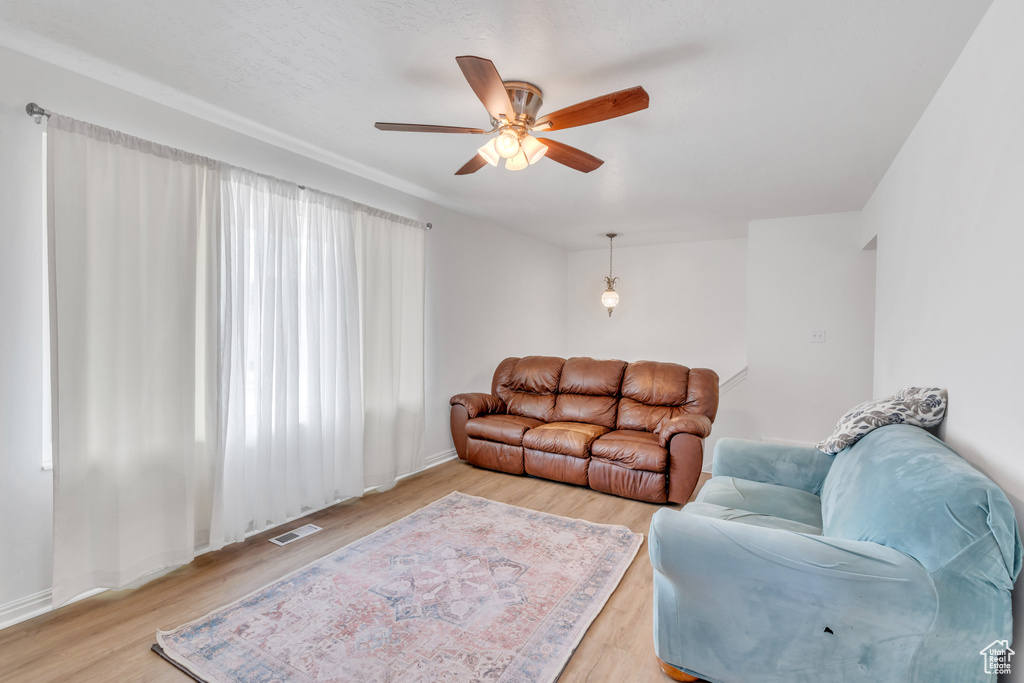 Living room featuring light hardwood / wood-style flooring and ceiling fan