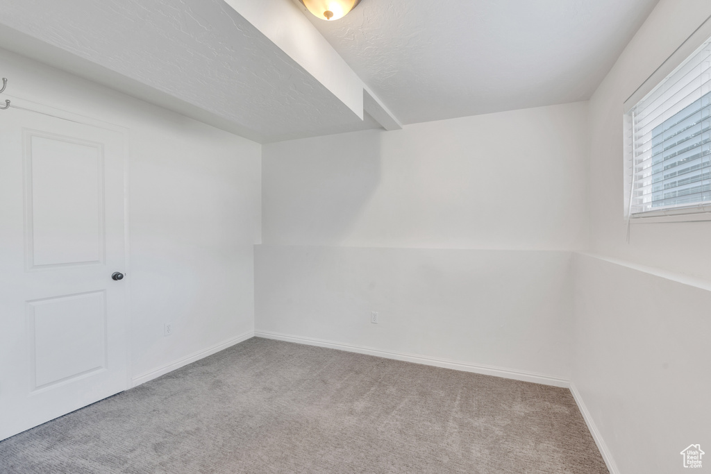 Unfurnished room featuring a textured ceiling and light carpet