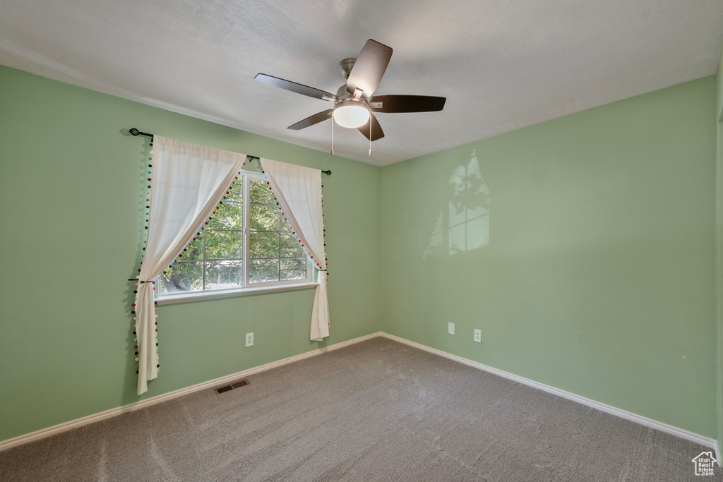 Unfurnished room with ceiling fan and carpet floors