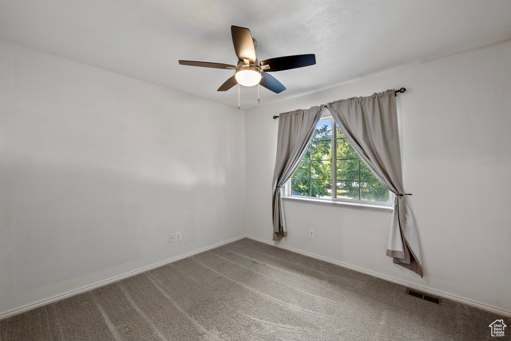 Spare room featuring ceiling fan and carpet flooring