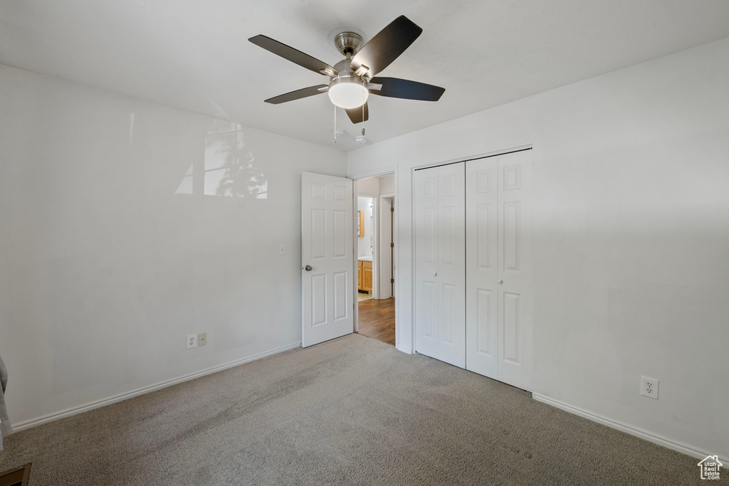 Unfurnished bedroom with light carpet, ceiling fan, and a closet