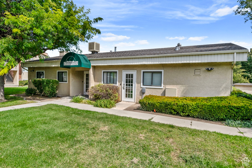 Ranch-style house featuring central air condition unit and a front yard