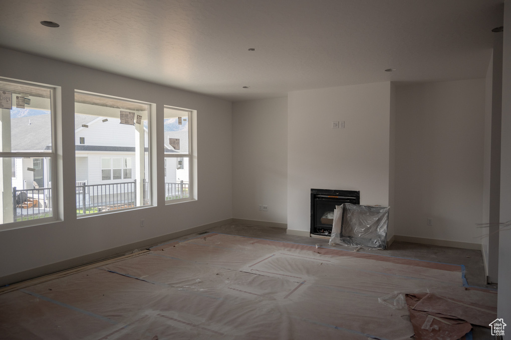 Unfurnished living room with a wealth of natural light and a fireplace