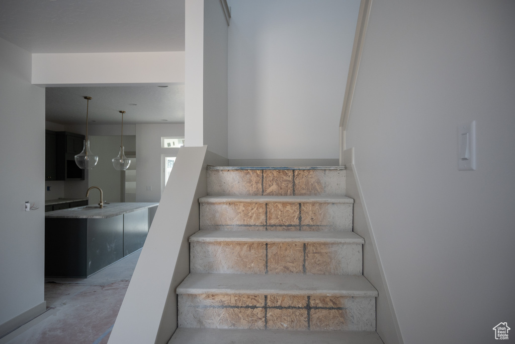 Staircase featuring concrete floors and sink