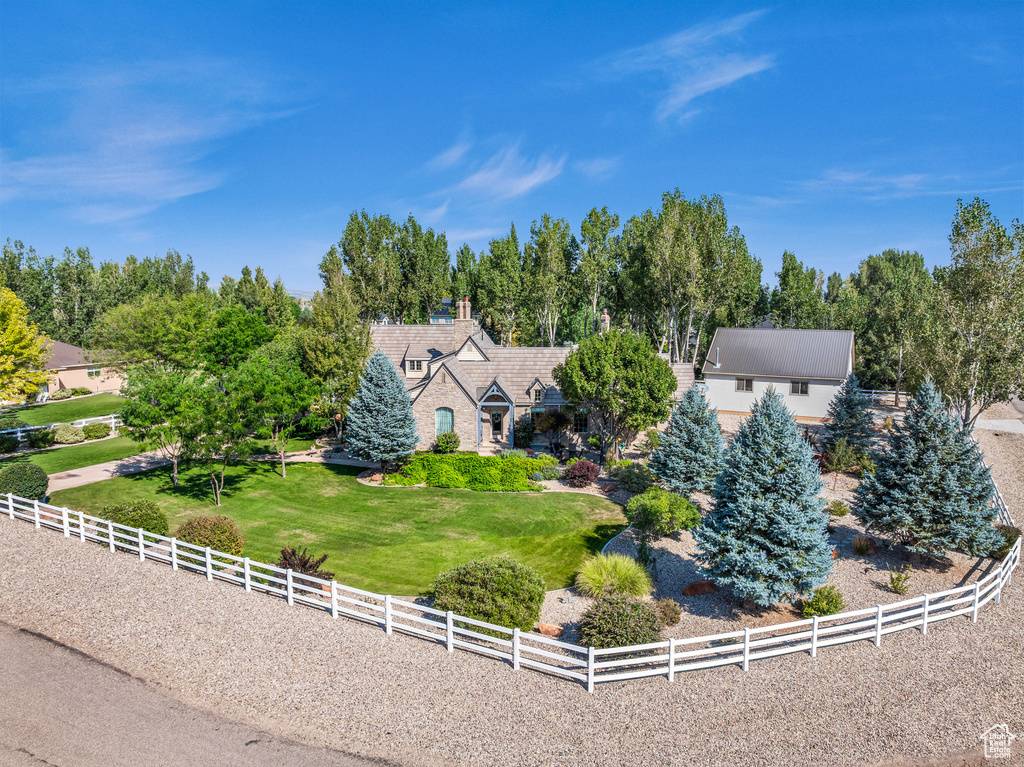 View of front of home featuring a rural view, fence, and a front lawn