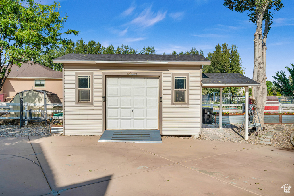 Garage with concrete driveway and fence