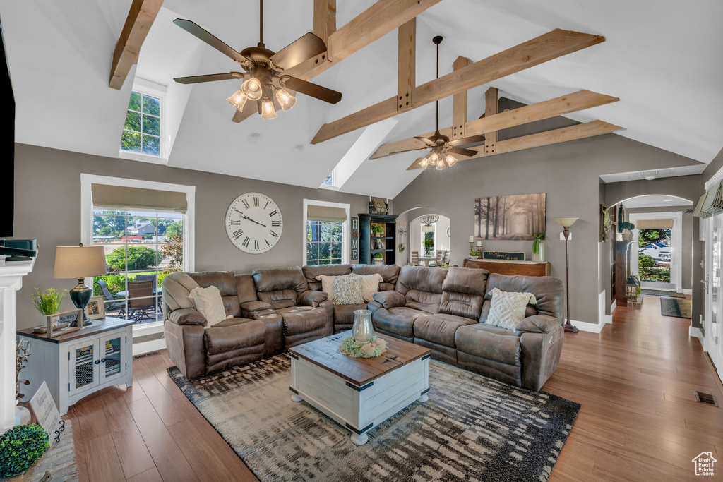 Living room with high vaulted ceiling, ceiling fan, and wood-type flooring