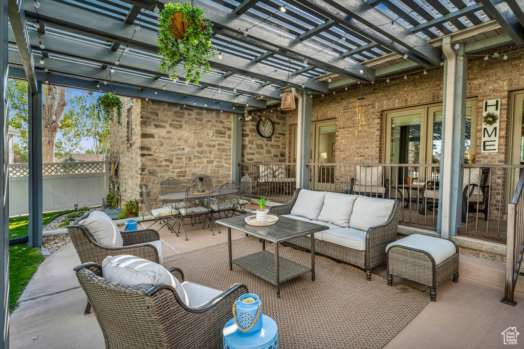 View of patio with outdoor dining area, outdoor lounge area, fence, and a pergola