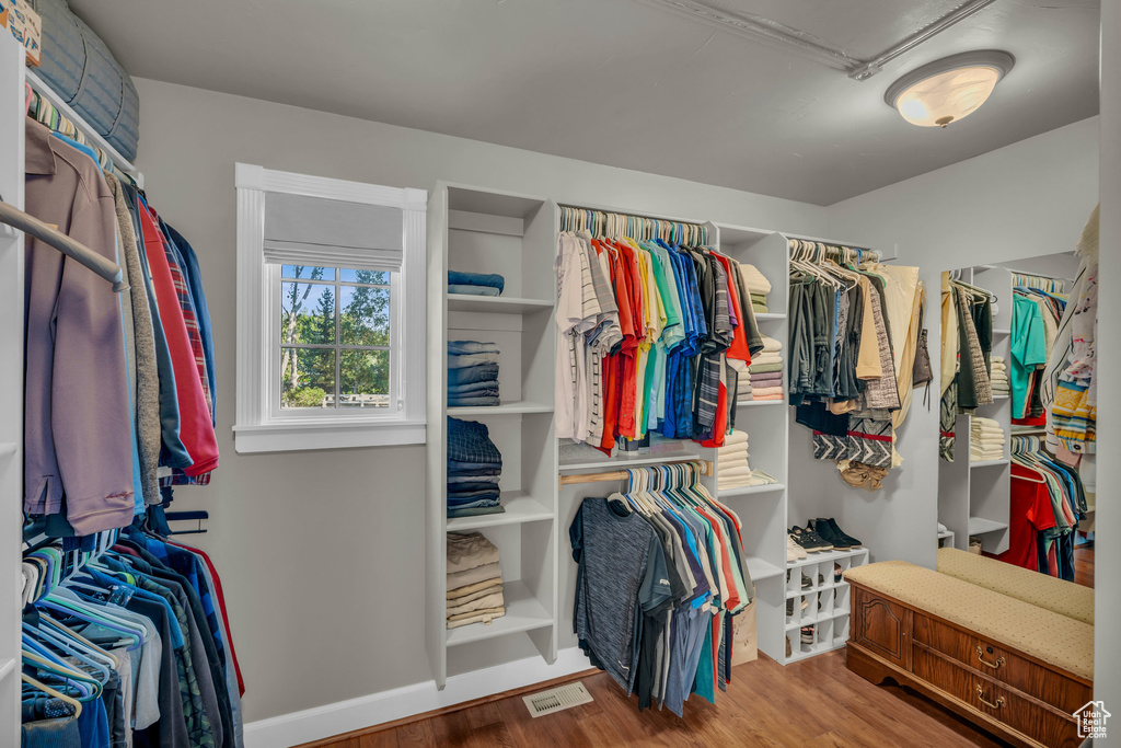 Walk in closet with wood-type flooring