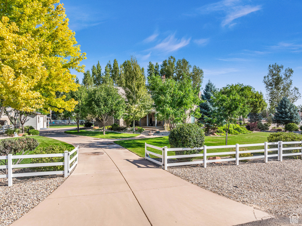 View of community with a fenced front yard and a lawn