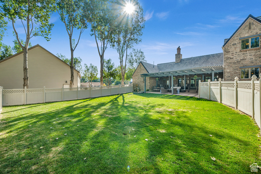View of yard with a fenced backyard, a pergola, and a patio