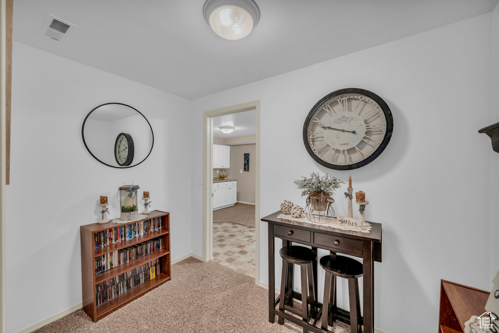 Hallway featuring light colored carpet, visible vents, and baseboards