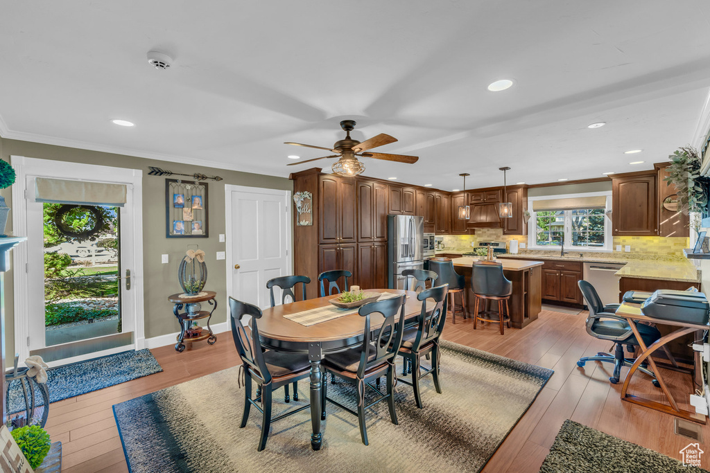 Dining space with crown molding, ceiling fan, and hardwood / wood-style flooring