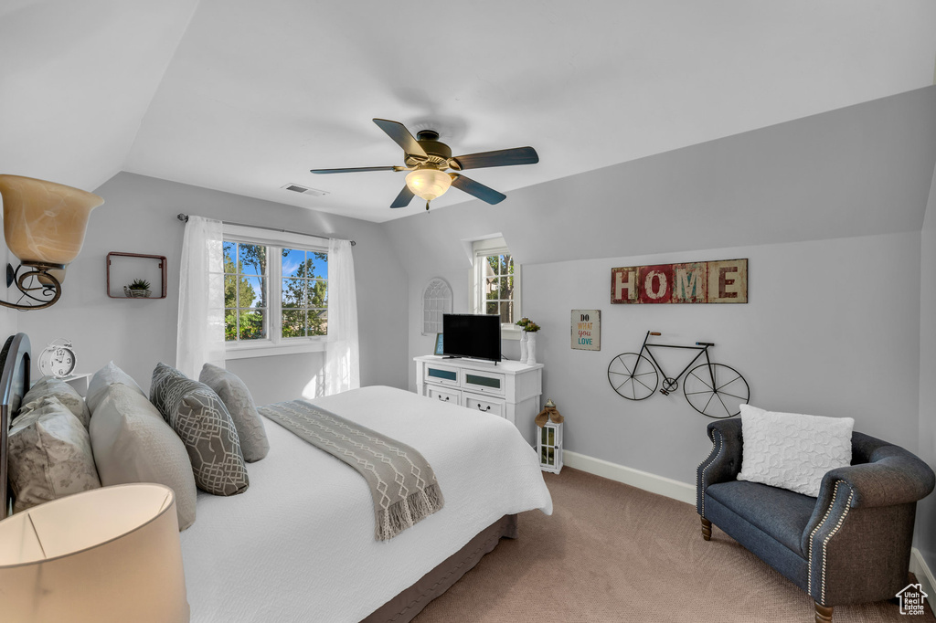 Carpeted bedroom featuring lofted ceiling and ceiling fan