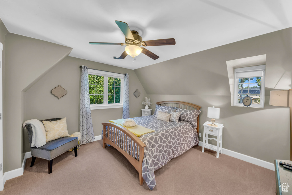 Carpeted bedroom with a ceiling fan, lofted ceiling, and baseboards