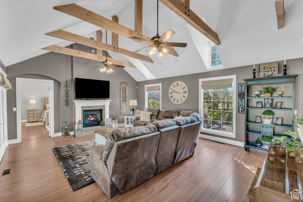 Living room with ceiling fan, beamed ceiling, high vaulted ceiling, and hardwood / wood-style flooring