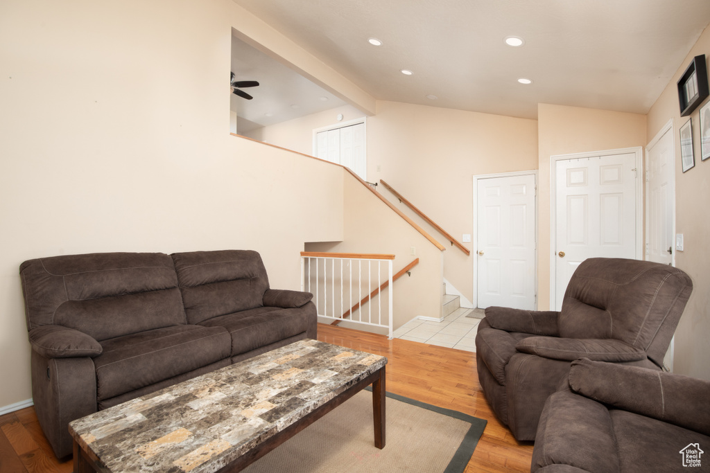 Living room with light wood-type flooring, ceiling fan, and vaulted ceiling