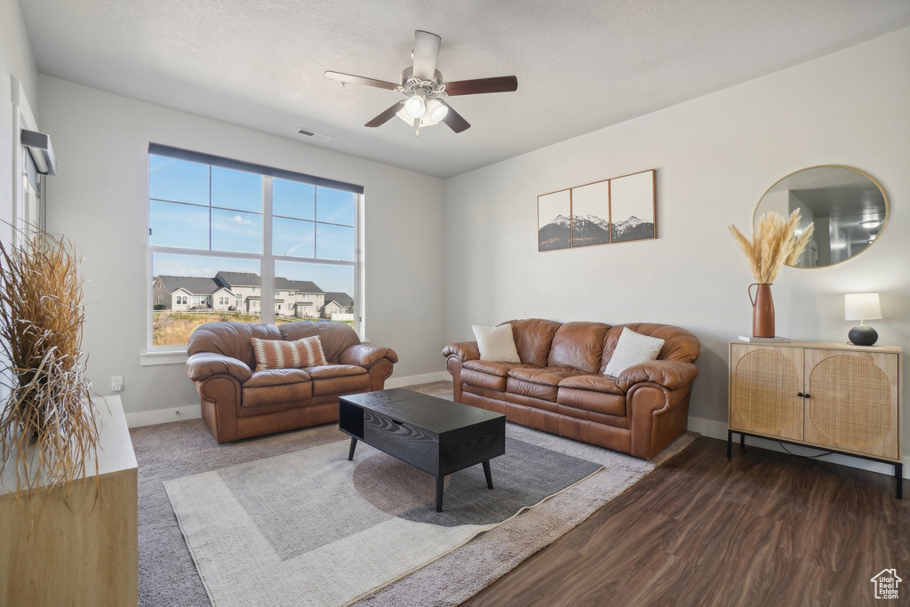 Living room featuring dark wood-type flooring and ceiling fan