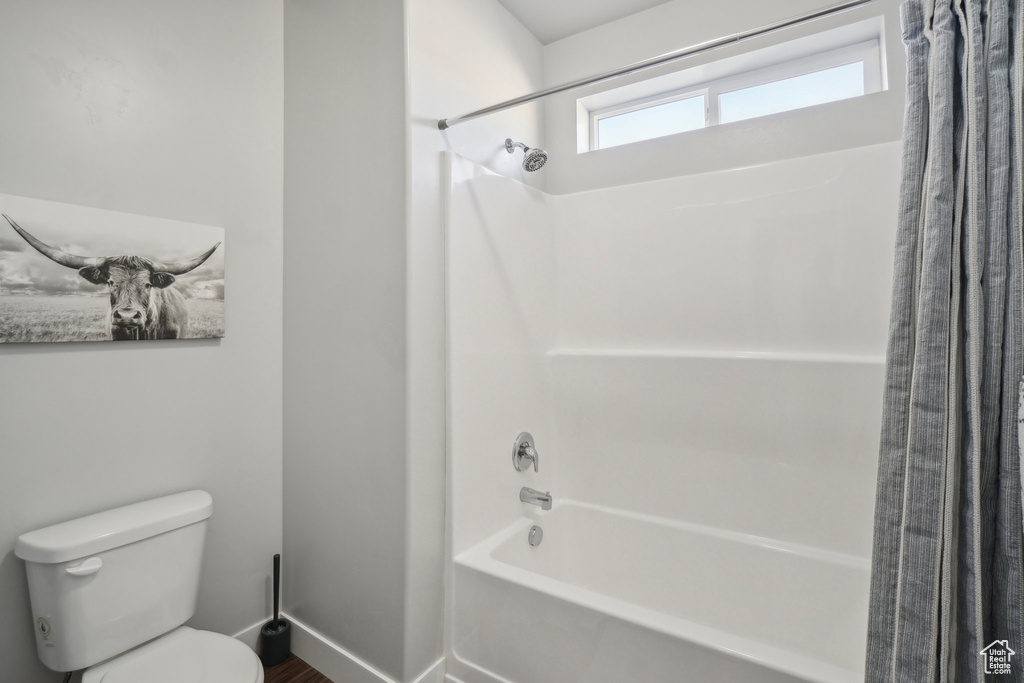 Bathroom featuring shower / bath combo and toilet