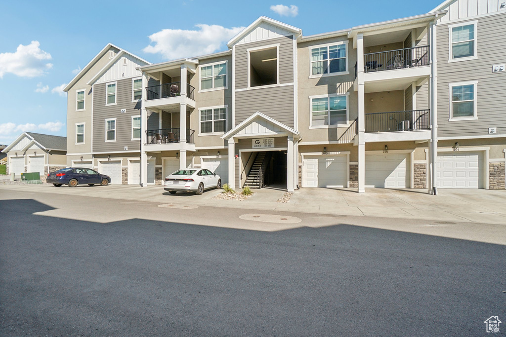 Exterior space with a garage and a balcony