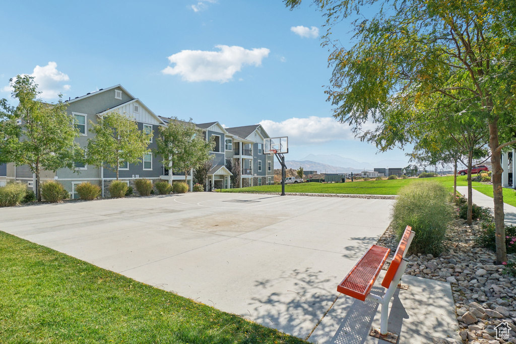 View of home's community with a mountain view, a yard, and basketball court