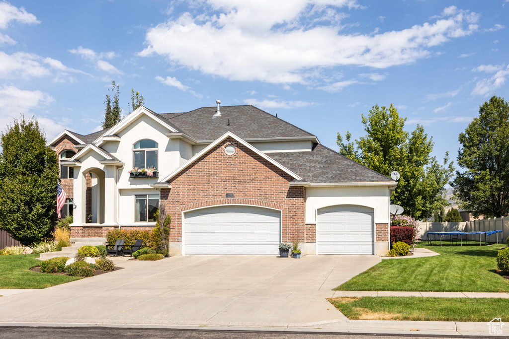 View of front property with a front yard and a garage