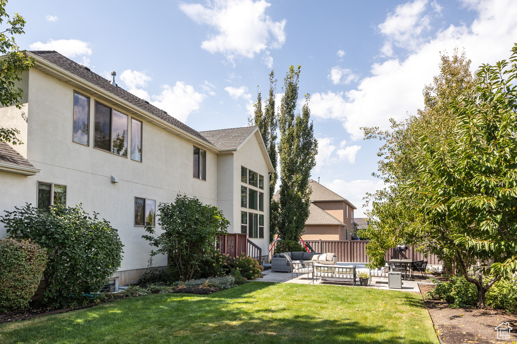 Rear view of property with a yard, an outdoor hangout area, and a patio area