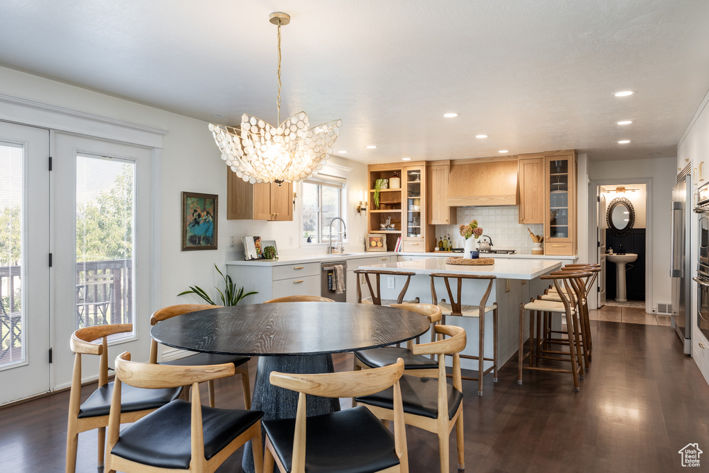 Dining area featuring a wealth of natural light, dark wood-type flooring, and a notable chandelier